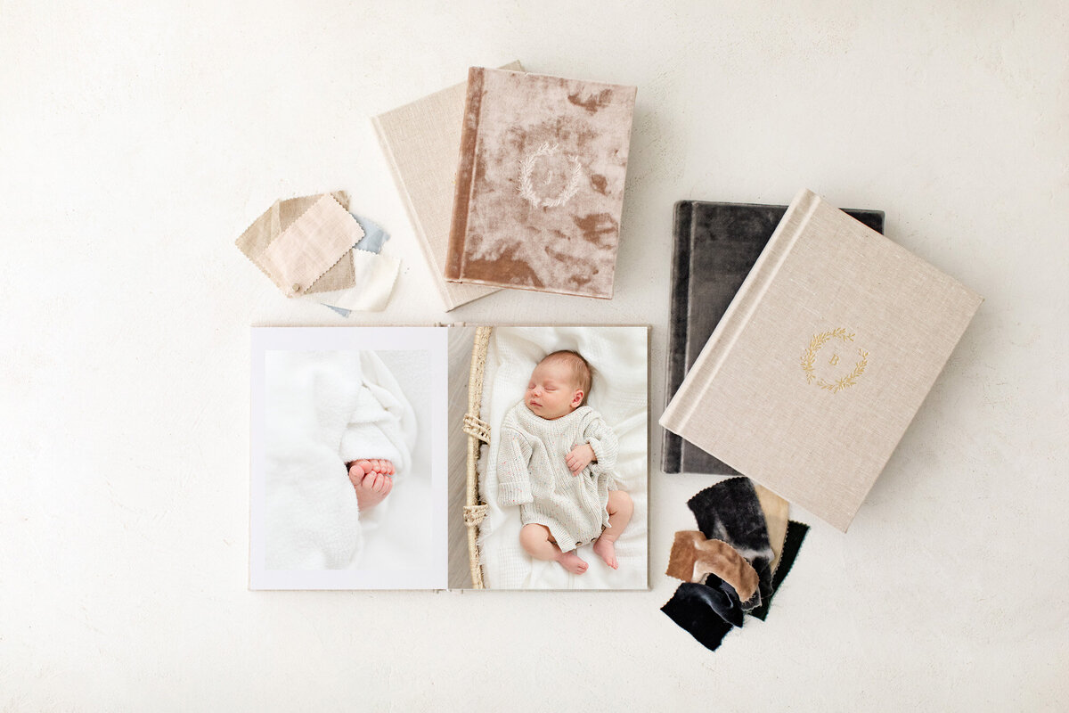 A group of beautiful photography products laid out featuring newborn photography by Missy Marshall