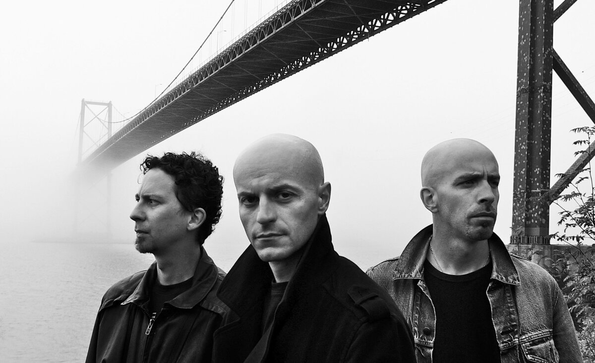 Musical trio portrait Brite Vu black and white standing beneath foggy bridge
