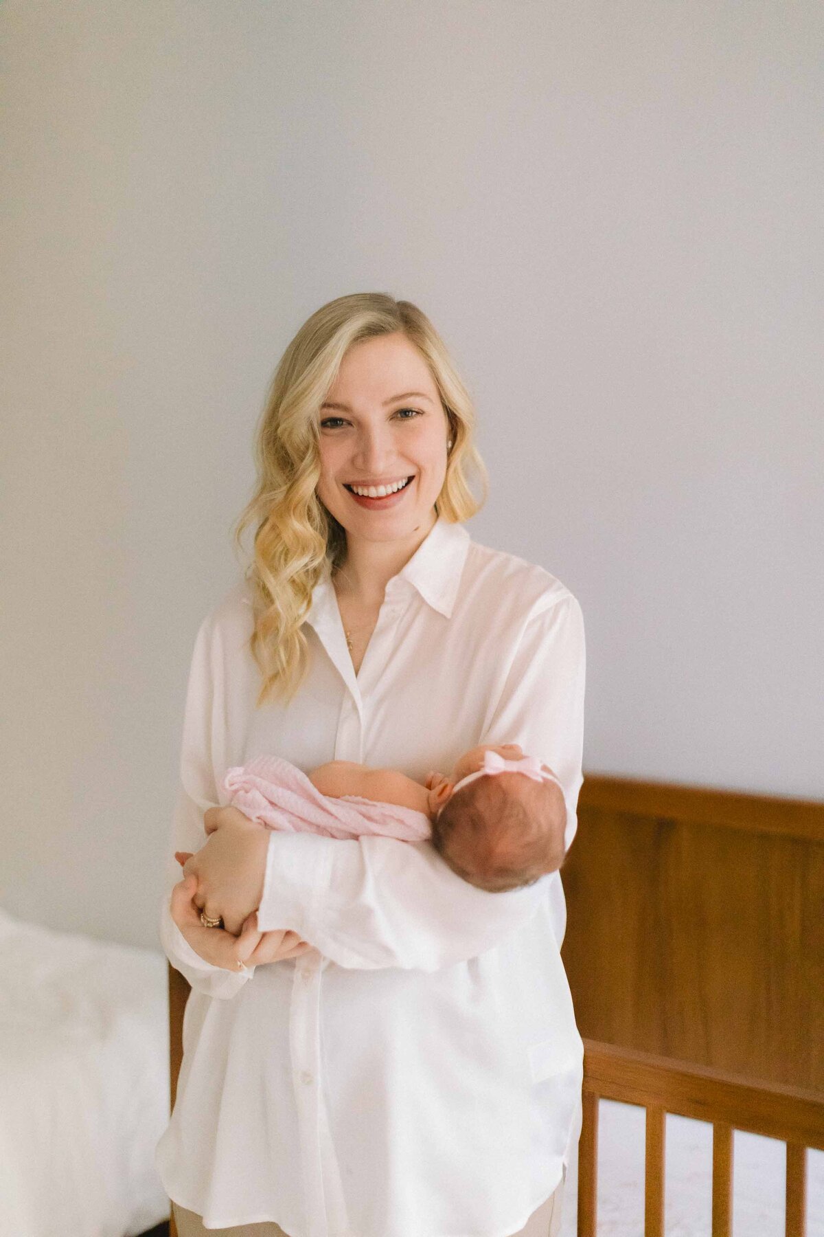 new mom smiling and holding her newborn baby girl