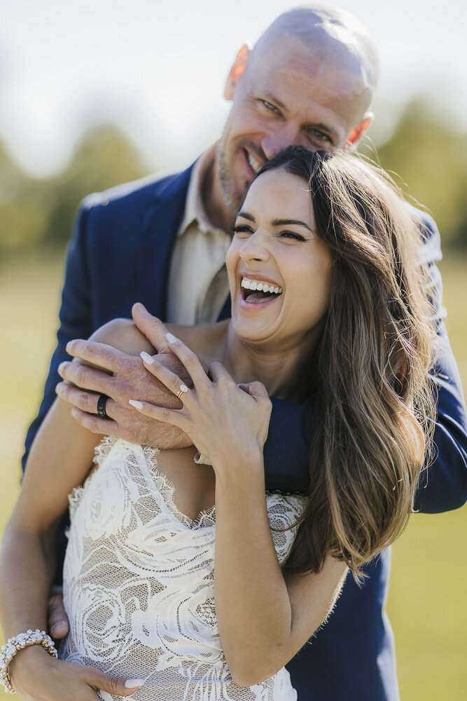 a bride and groom smiling while embracing
