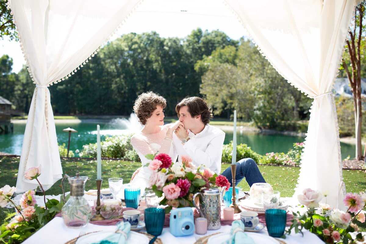 Groom kissing brides hand during a romantic moment at a wedding at Walnut Hill in Raleigh, NC