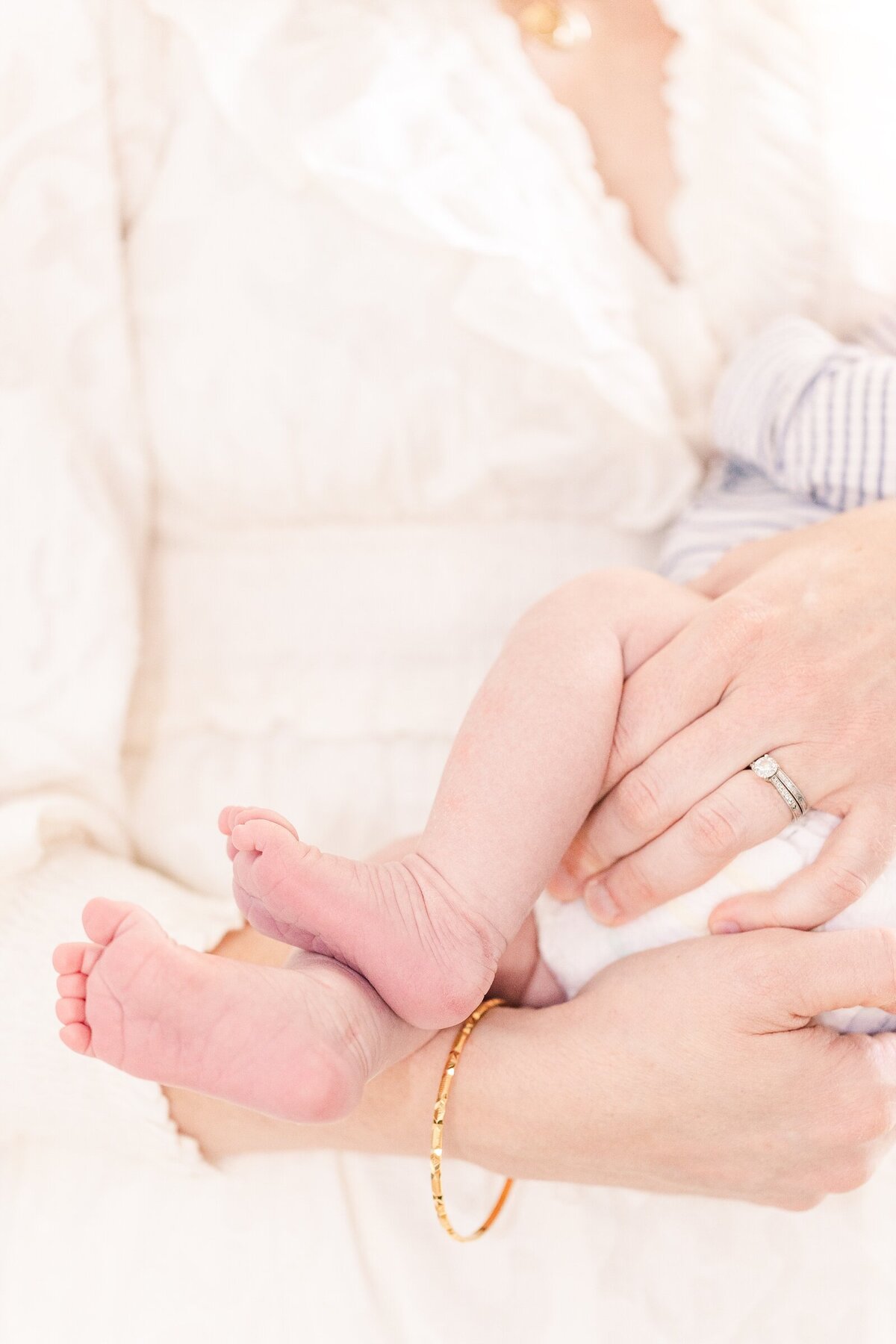 Closeup of mom's hands holding baby toes for Erin Thompson Photography