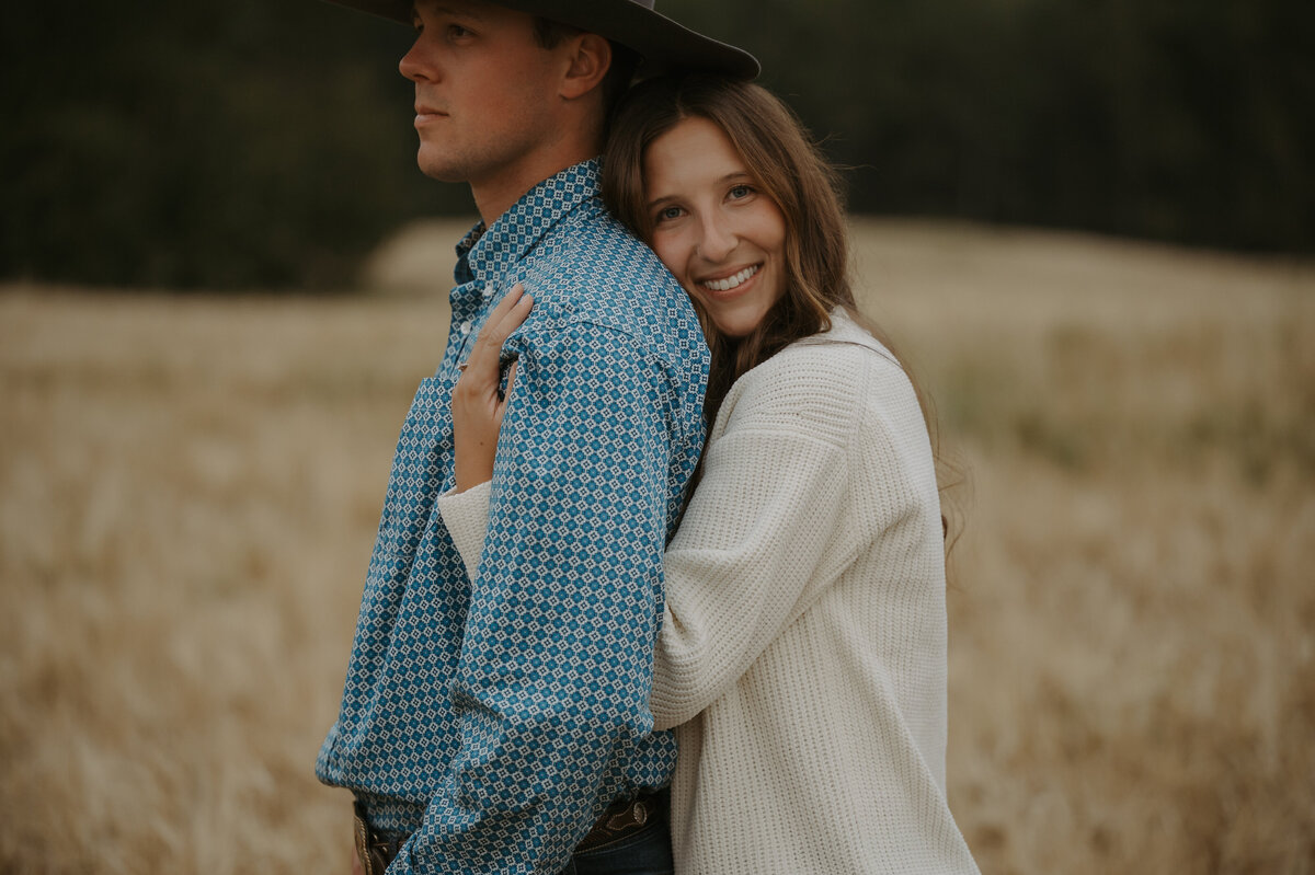Photograph of girl snuggling into her partner in an Alberta field 