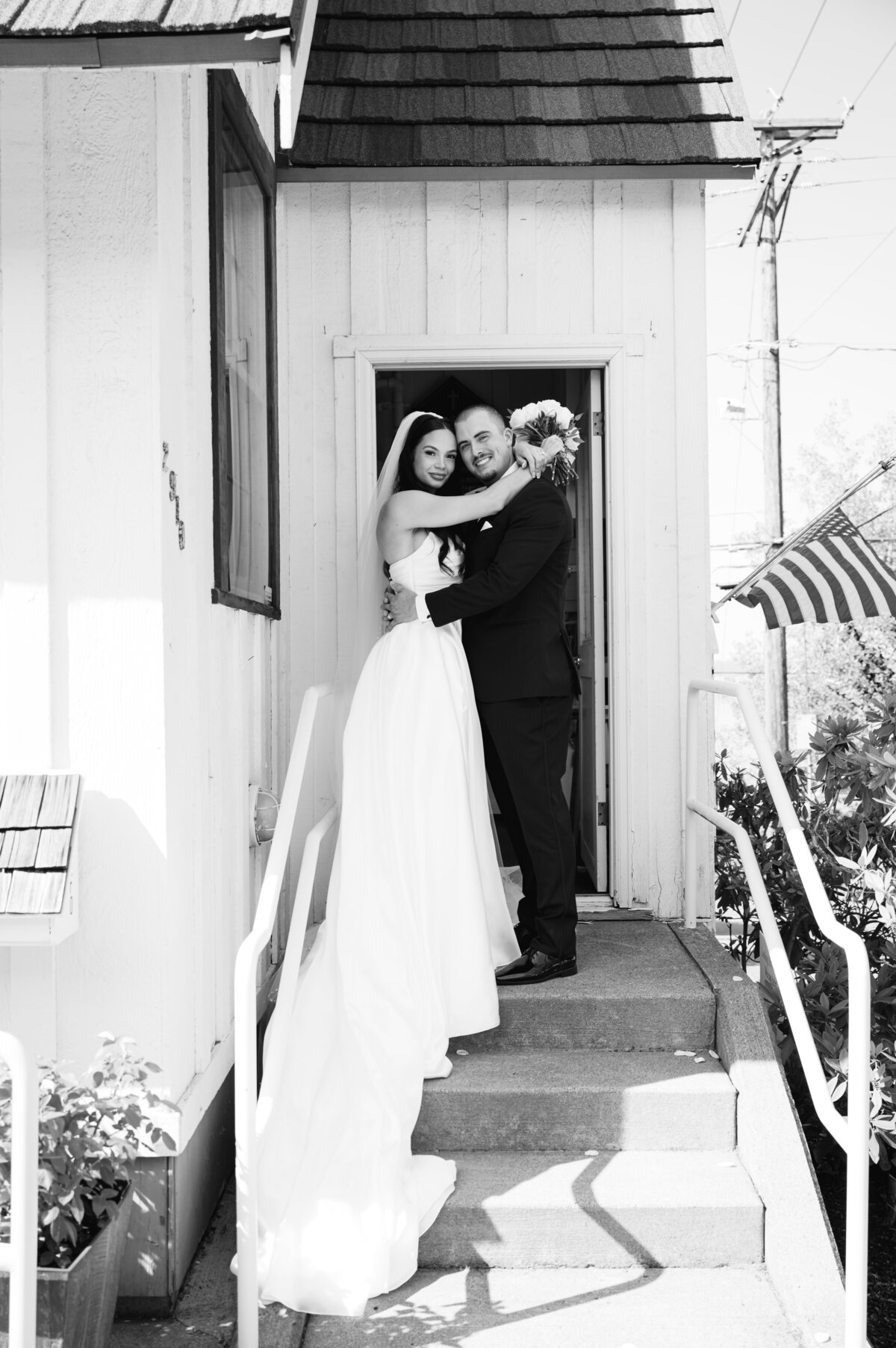 wedding bride and groom pose outside of white chapel in tacoma washington