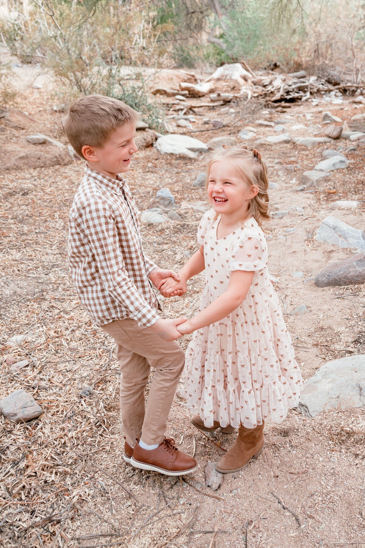 brother and sister holding hands laughing in north scottsdale arizona