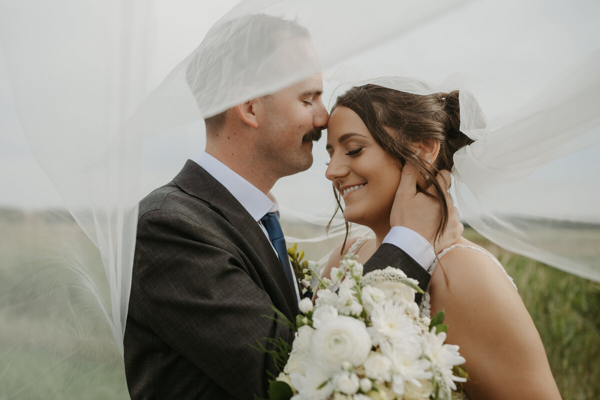 bride and groom under the viel on wedding day 