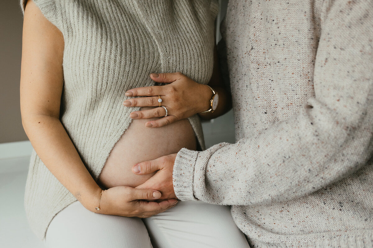 Fotoshoot zwanger details buik handen thuis