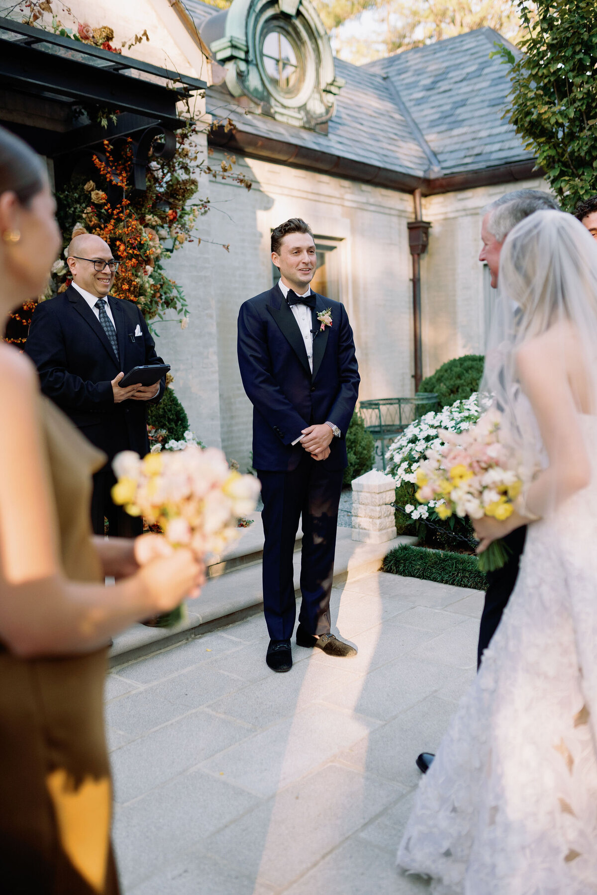 Product clustered bridal bouquet with sweet peas, local zinnias, and butterfly ranunculus. Elegant and simple bridal bouquet and bridal party bouquets with hues of blush and pops of yellow. Unique fall wedding design for private residence wedding in Nashville, TN. Bridal party wearing brown and wedding design with touches of brown. Design by Rosemary & Finch Floral Design in Nashville, TN.