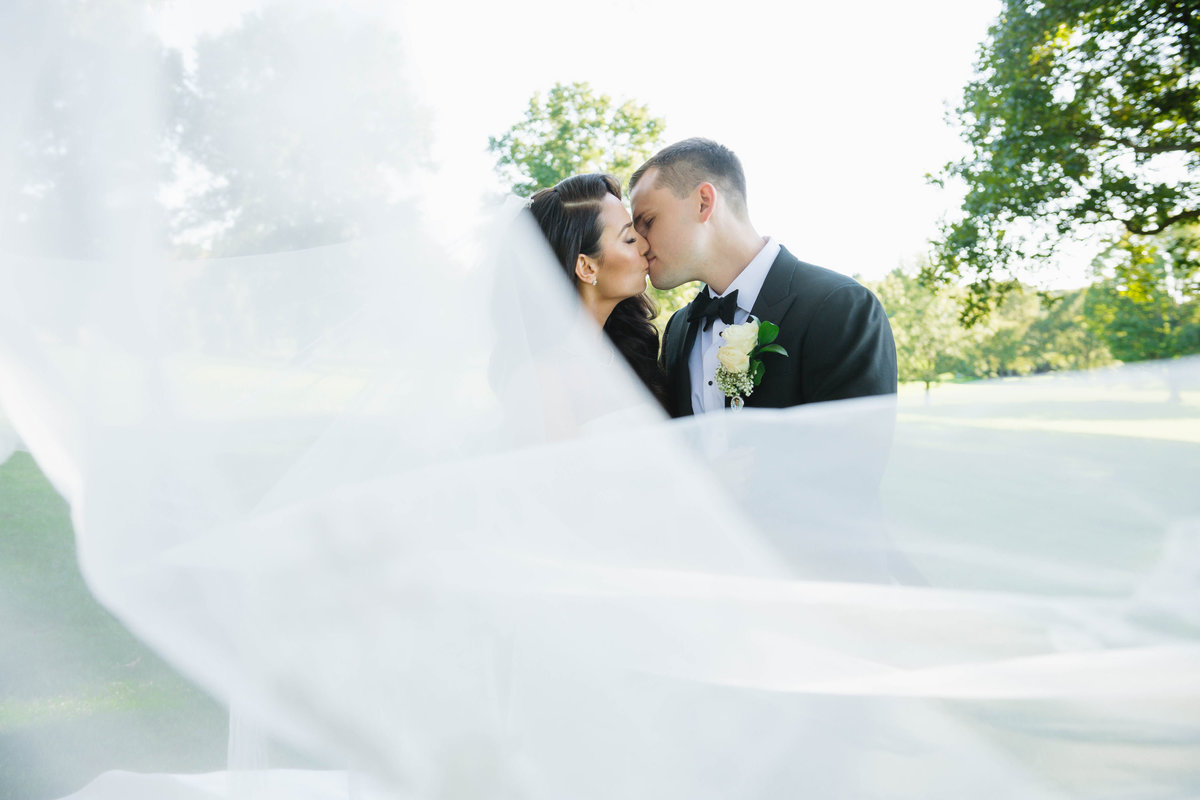 bride and groom kissing photo outside at The Muttontown Club