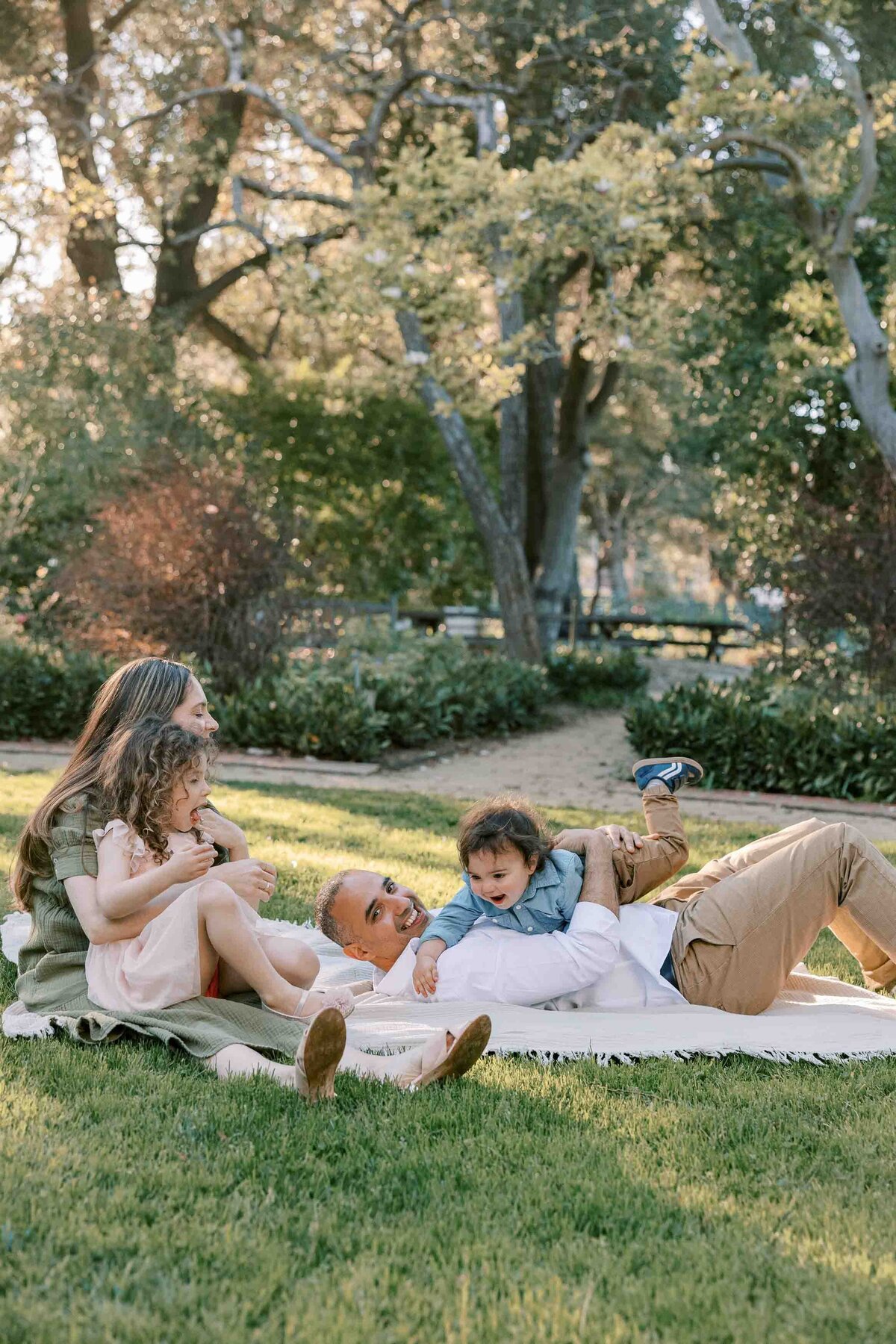 family having tickle fight at gamble garden palo alto
