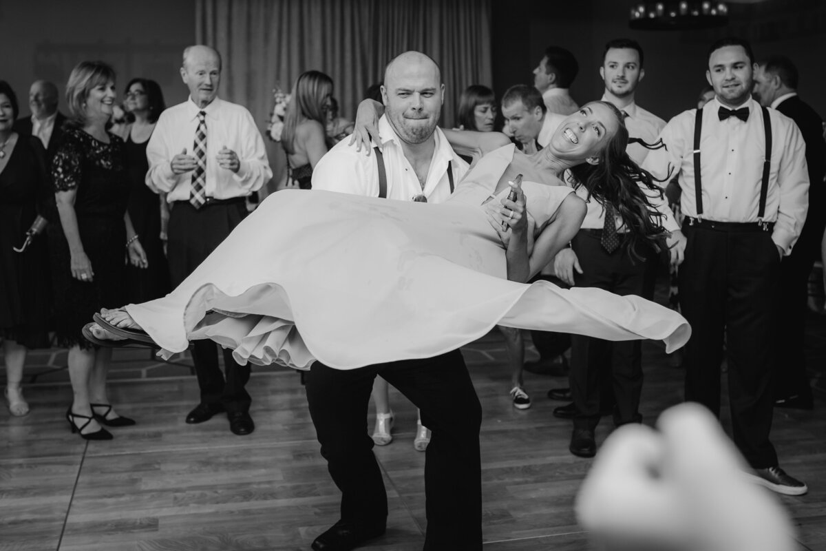 Black and white photograph of bridal party dancing at a wedding.