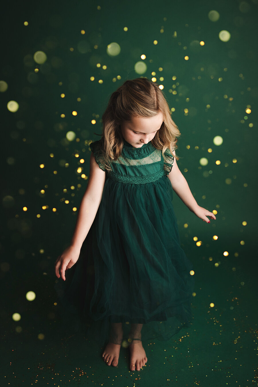 Older girl twirling in glitter on a green dress