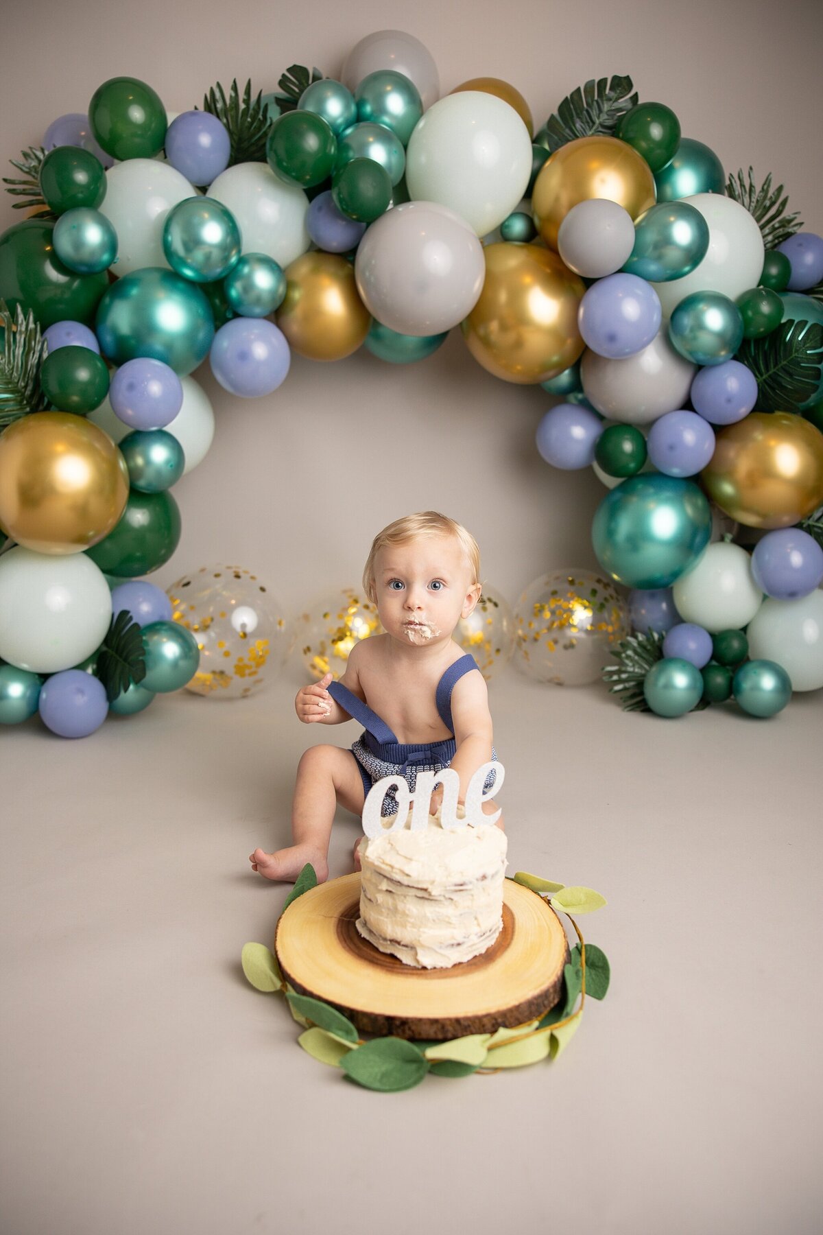 baby looking suprised in birthday cake smash pictures