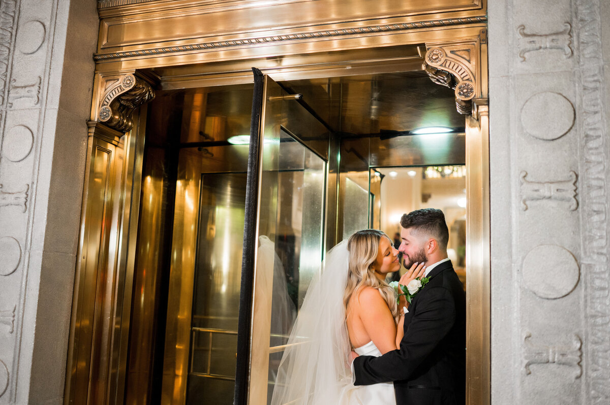 couple kissing in the revolving door entrance to omni hotel