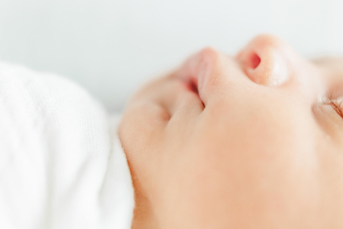 A closeup detail image of a newborn baby's cheek and lips