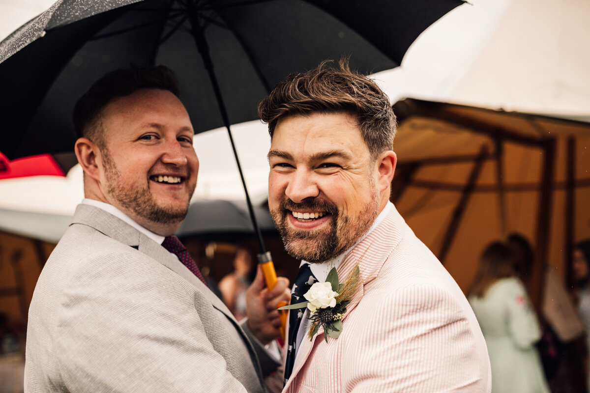 Groomsmen smiling at camera at outdoor wedding