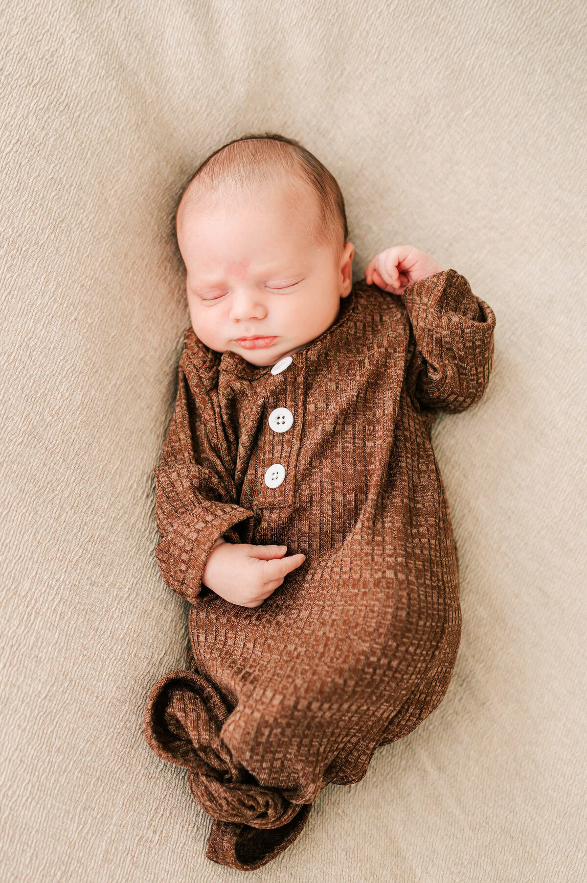 newborn in brown nightgown sleeping during Springfield MO newborn photography session