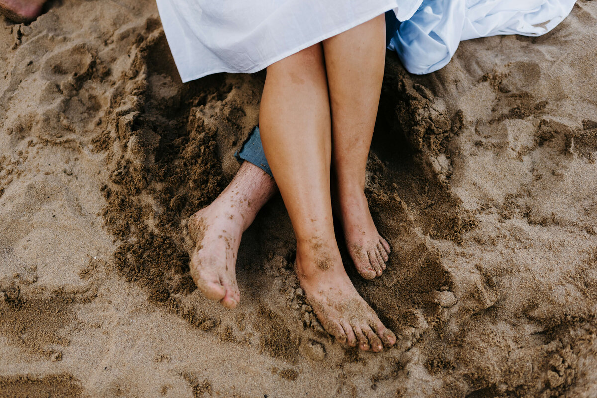 detail photo taken by Virginia wedding photographer for beach engagement photos with man and womans feet in the sand