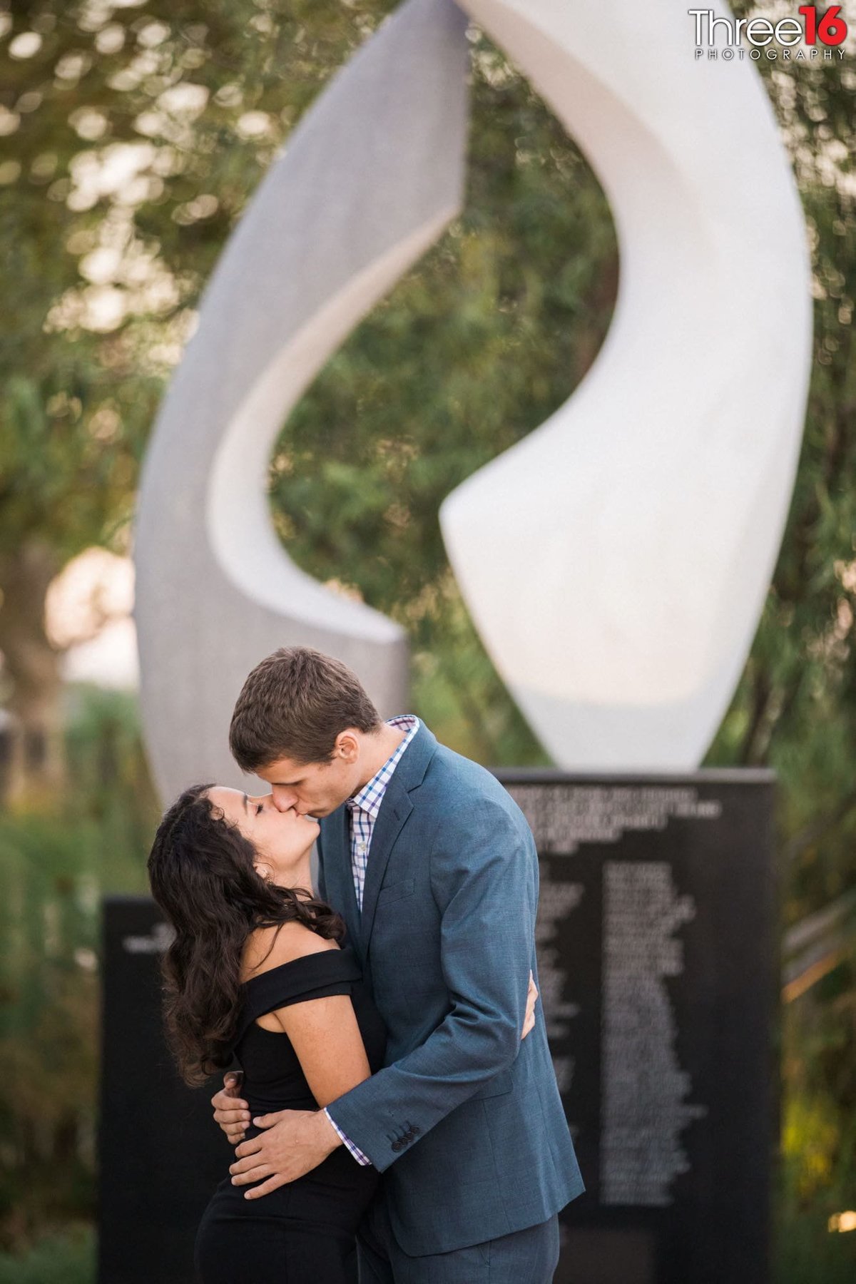 Engaged couple share a kiss at Sculpture Garden