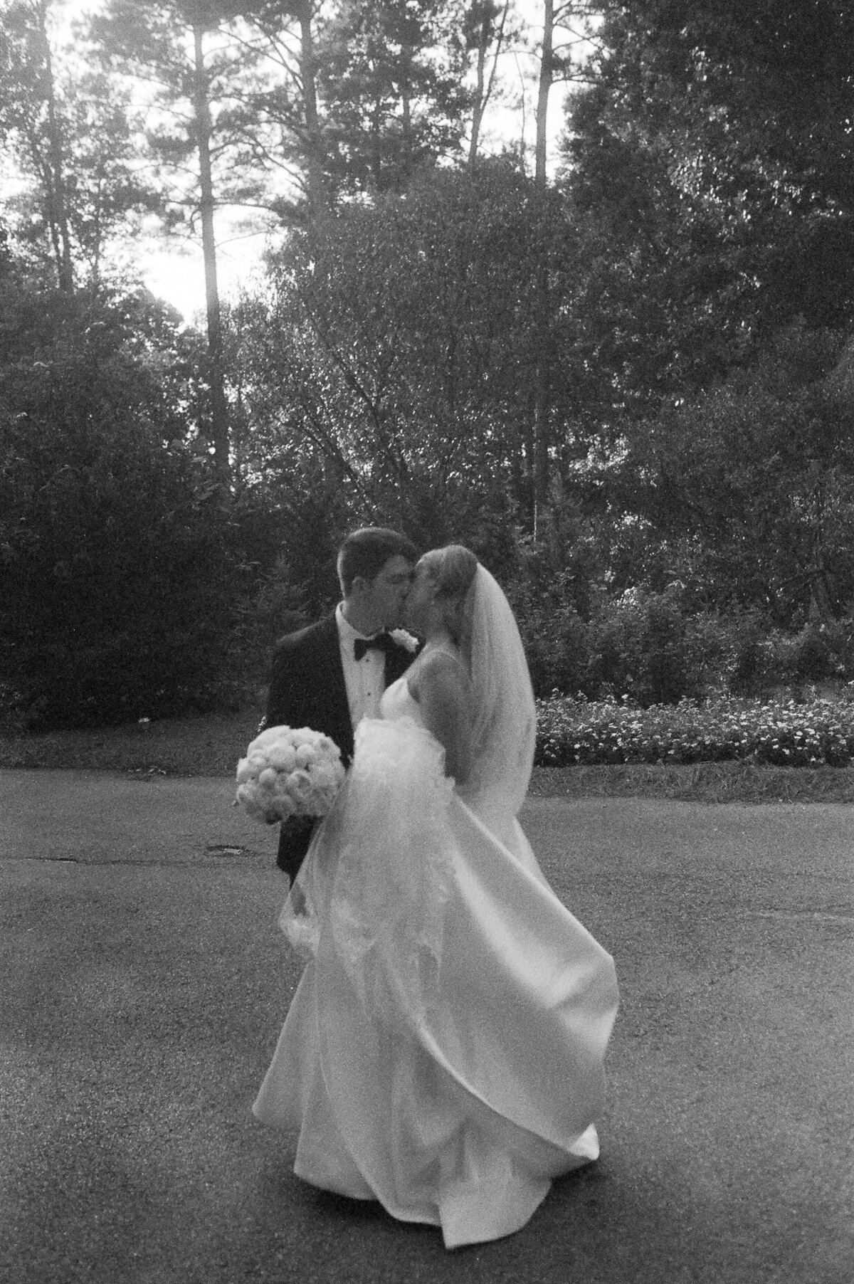 bride and groom film photography kissing on a golf course