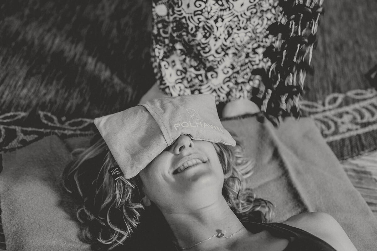 a lady lying down  with her eyes covered