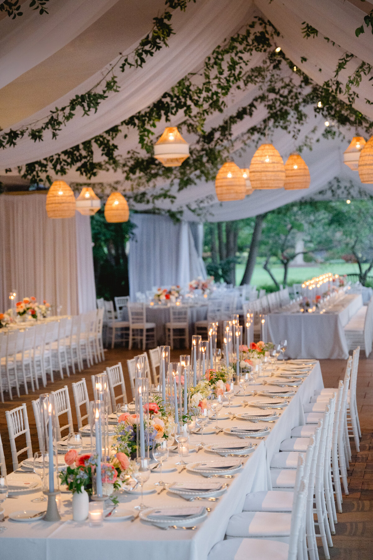 Long reception table under a tent adorned with string lights