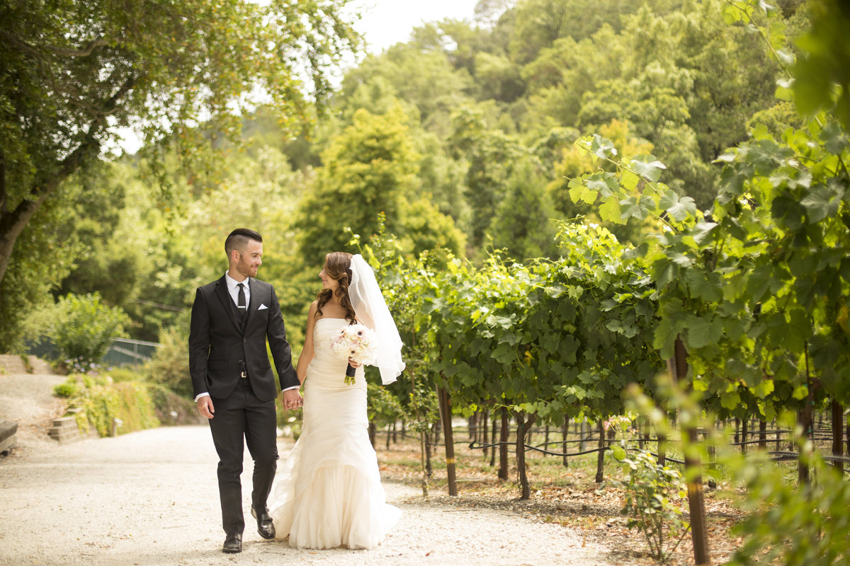 Wedding Photography, bride and groom walking though a vineyard
