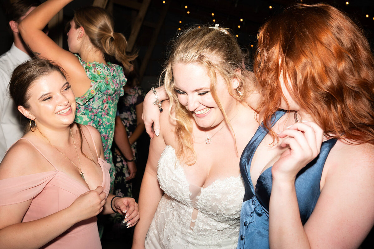 Bride dances with guests at wedding reception.