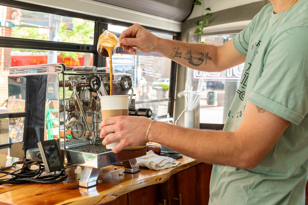 A double shot of espresso is poured into a large laté on the Buspresso mobile barista coffee bus in Denver, Colorado