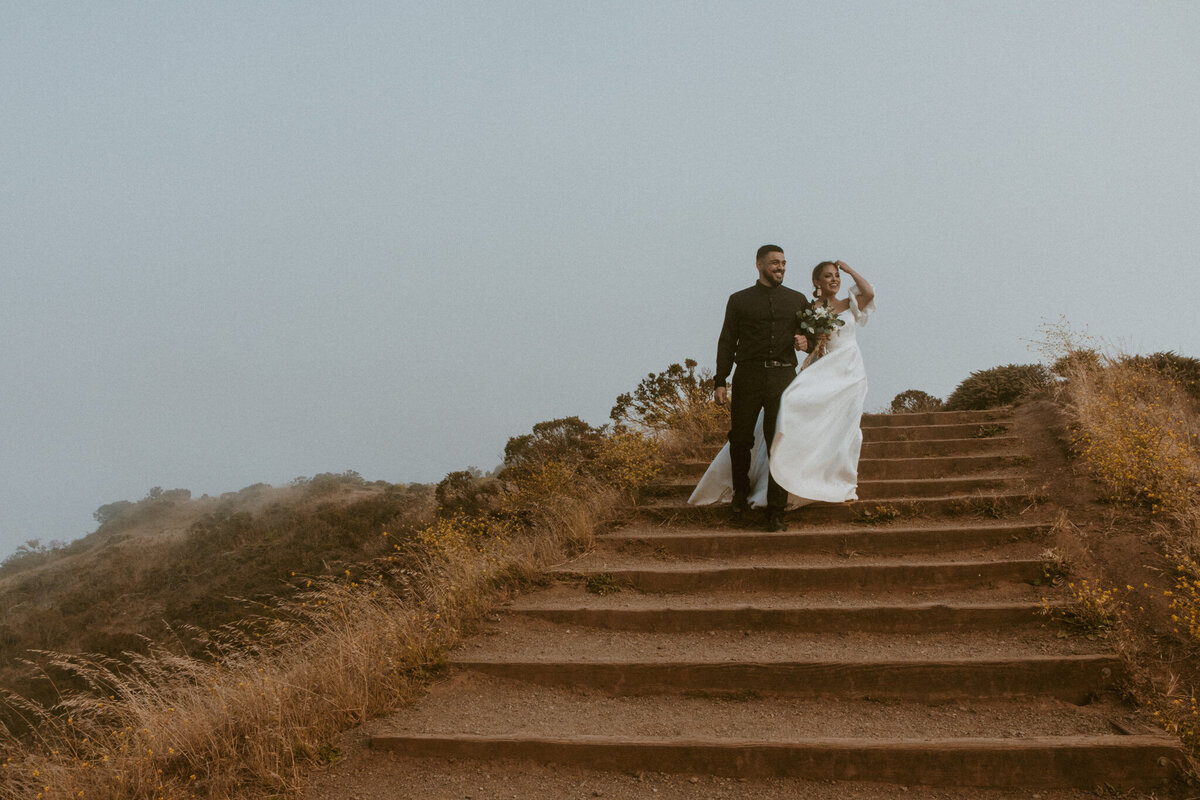 Bride and groom walking down outdoor staircase