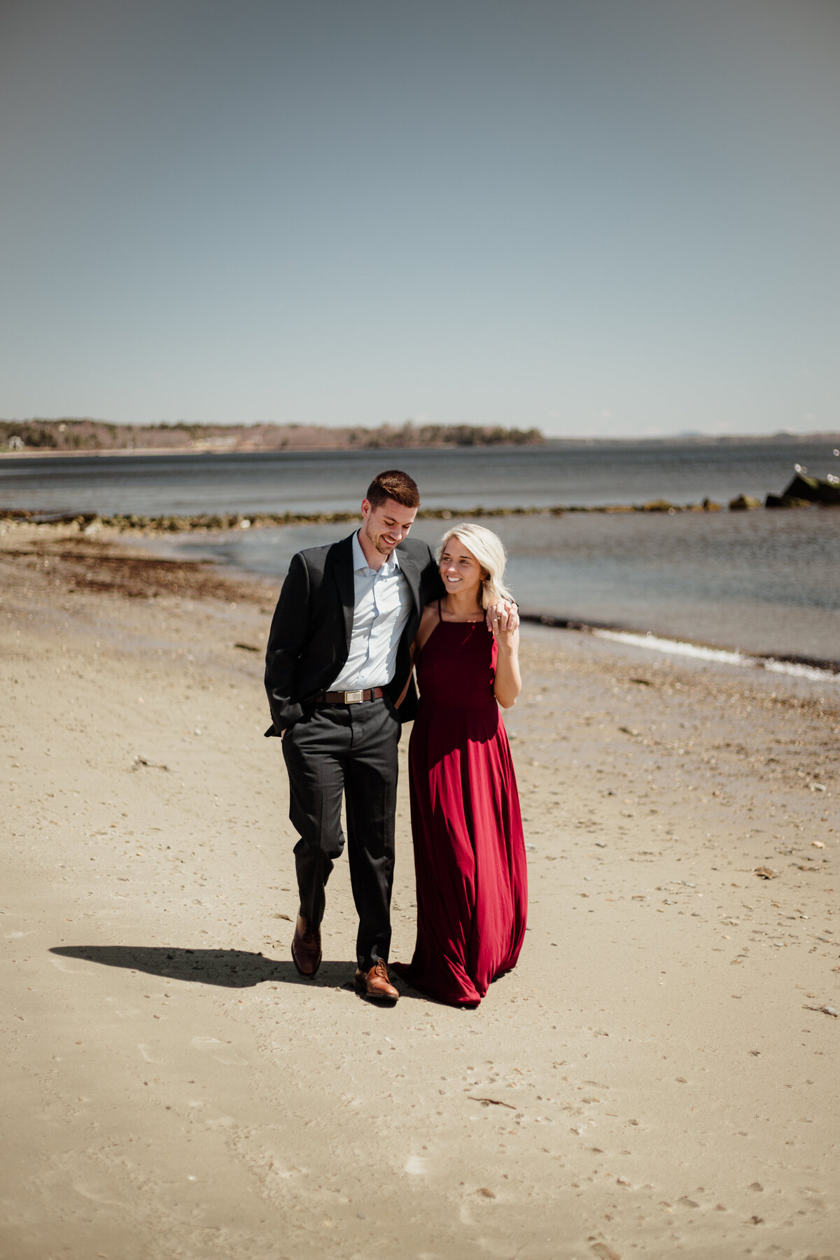 A romantic moment captured on Vermont's serene beaches, as a couple enjoys the sand, sea, and each other's company.