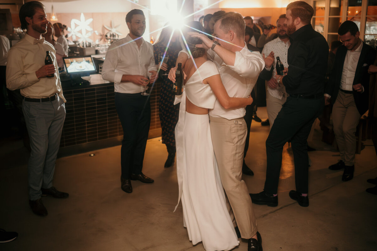 Wedding party photography of the newly weds dancing closely at their party.