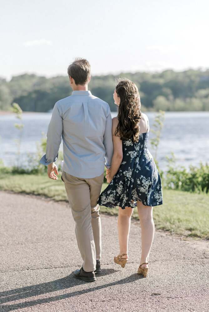 engaged couple walking by the lake