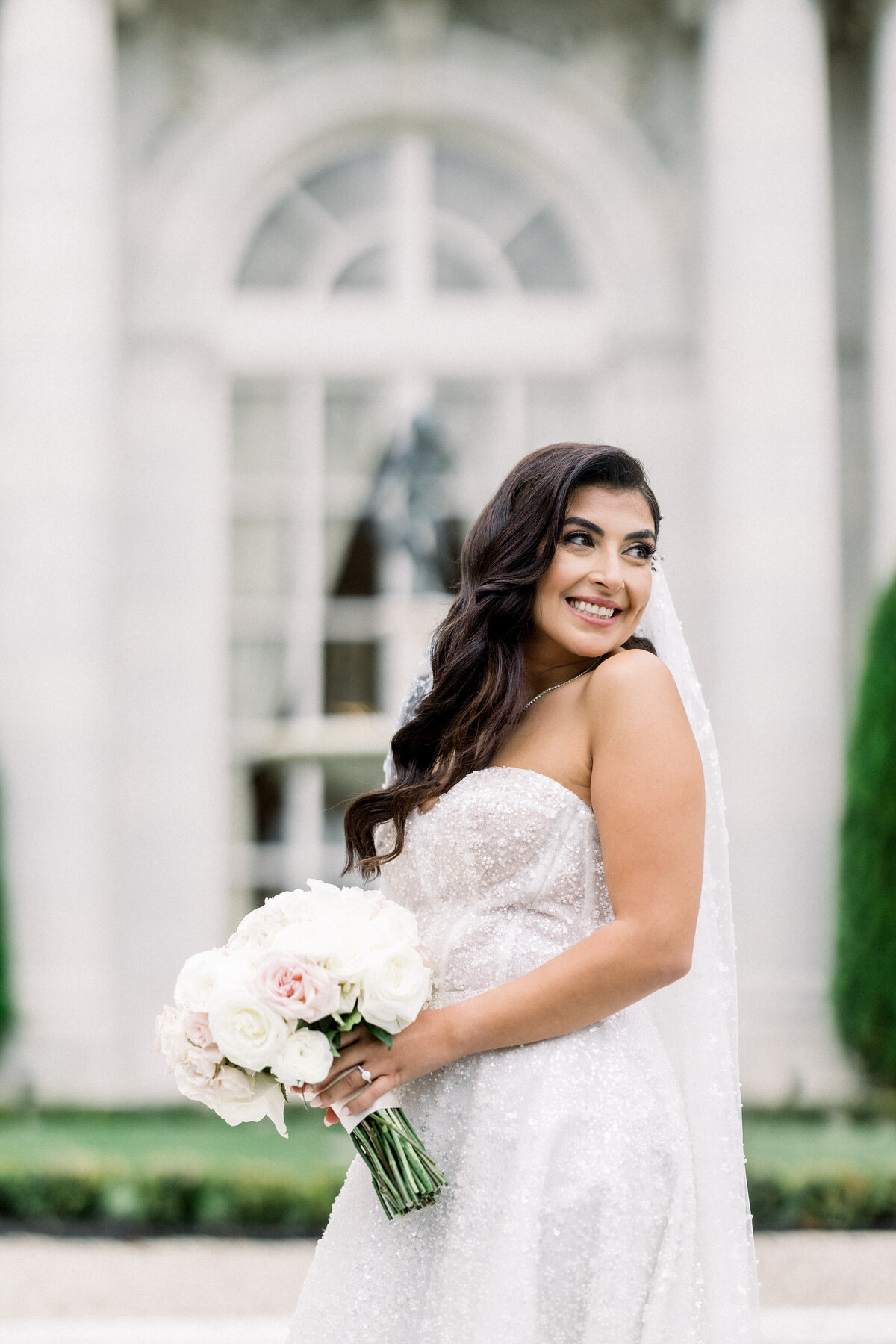 sophisticated bbride poses for glamorous bridal portrait  outside during wedding day portraits outside of rosecliff mansion in newport rhode island