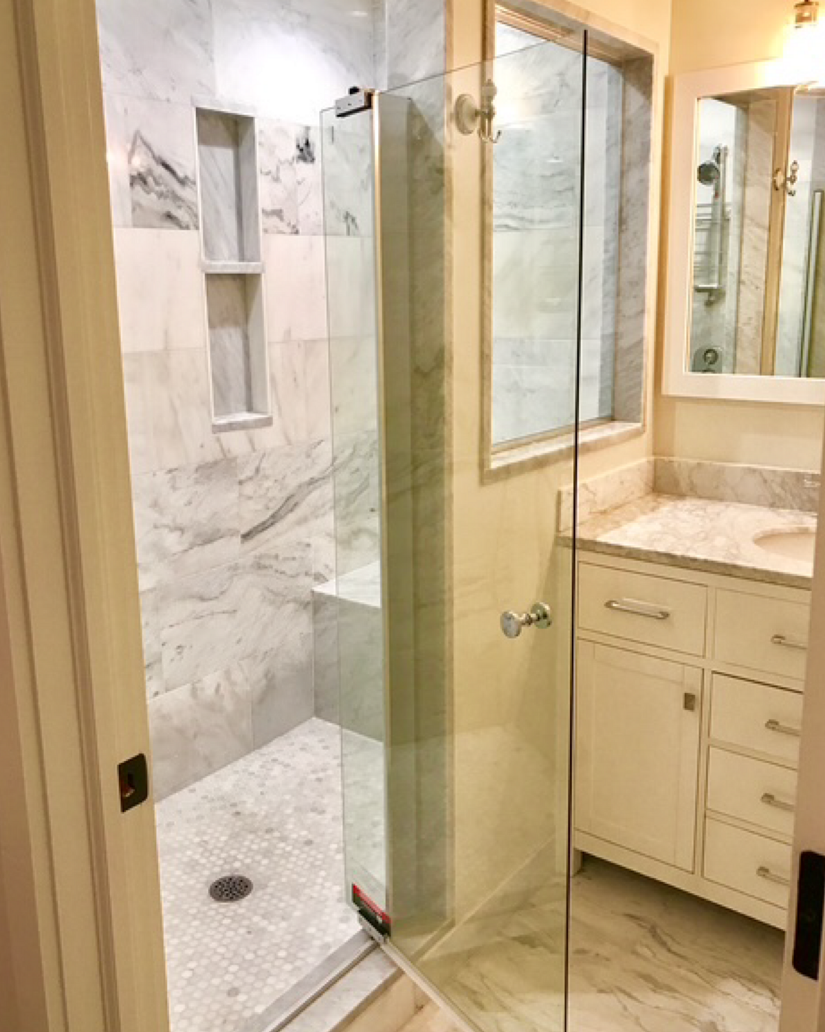 Clean walk in style french style clean, glass door. Bench seat in shower 