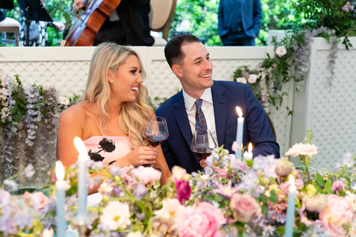 Growing, fresh floral centerpieces with blush garden roses, lilac, blue sweet peas, ranunculus, lavender delphinium, globe allium, and natural greenery for a tented Bridgerton inspired engagement party at a private home in Nashville, TN. Flower by Te