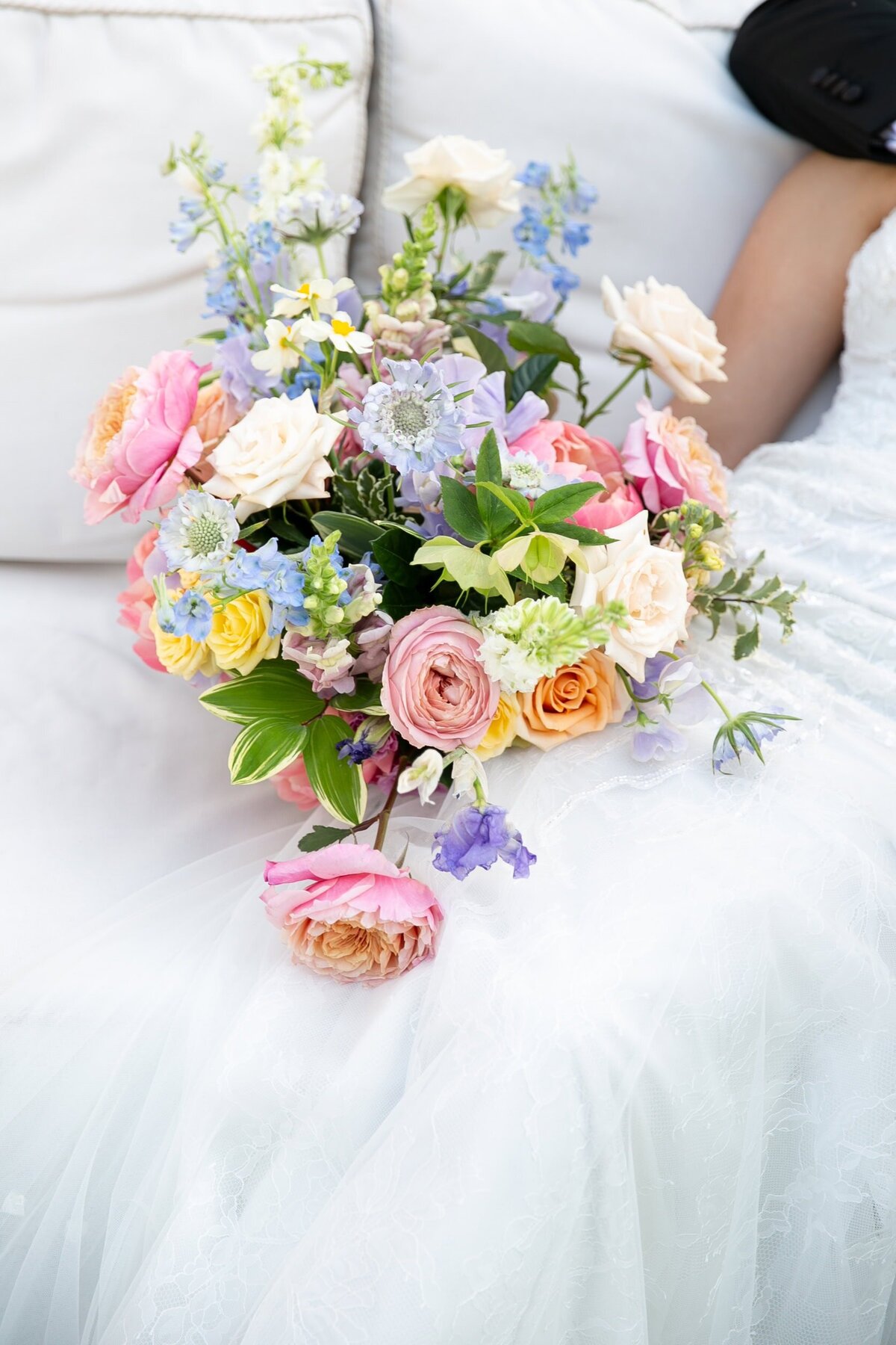 colorful wedding bouquet against a wedding dress. Bridal details.
