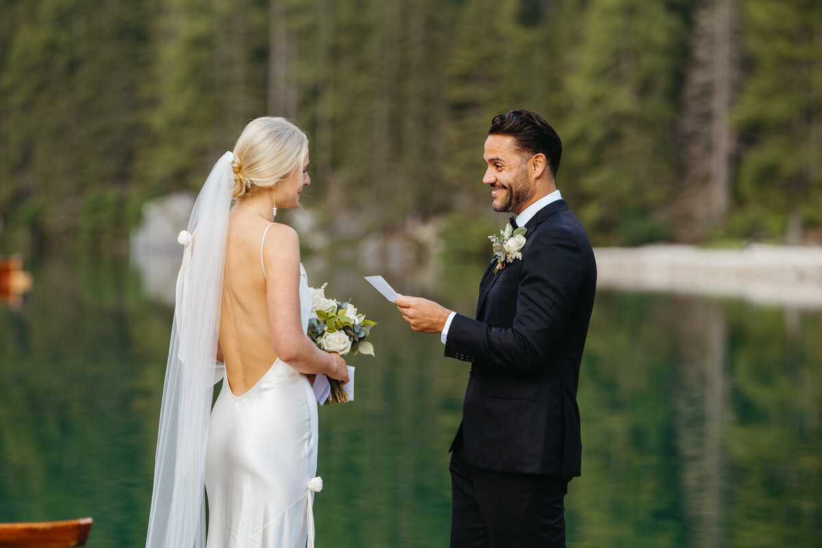 Bride holding bouquet while listening to groom’s vows