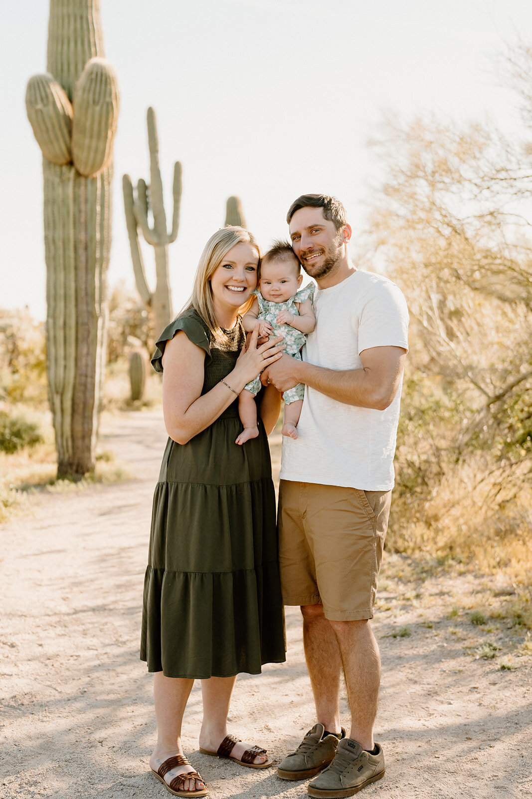 A family smiling at the camera in the desert