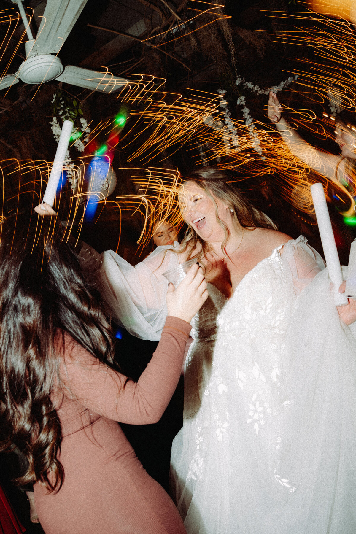 excited bride dancing with wedding guests at reception