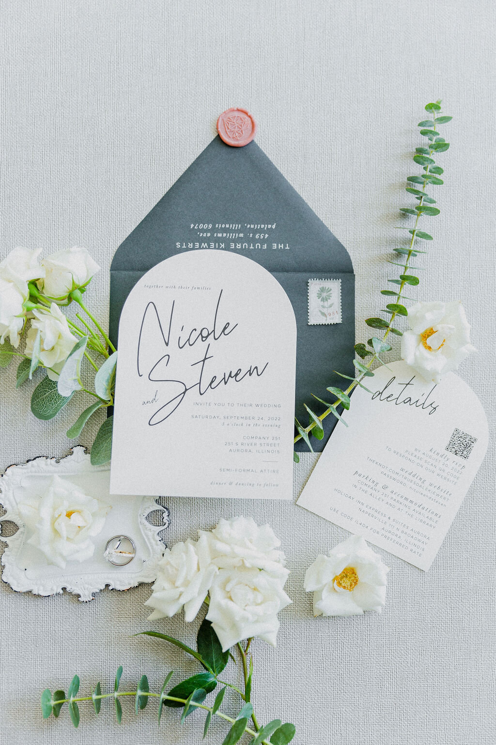 Artistic shot of wedding stationery, blending crisp white and lush green tones, showcasing the sophistication and attention to detail of the day