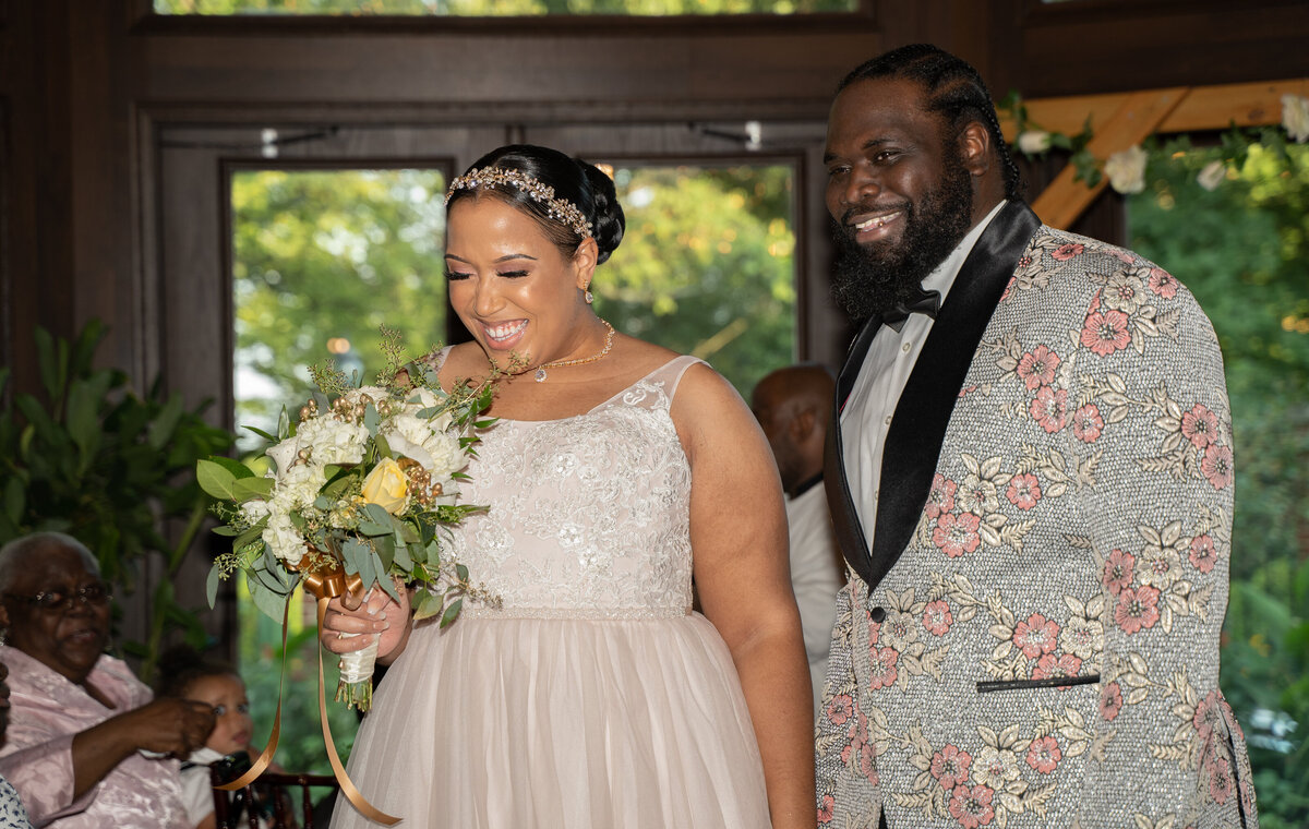 African American bride and groom smile after wedding ceremony.