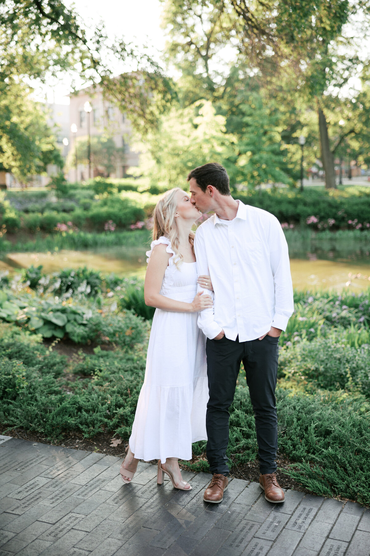 Couple kisses in lush Columbus garden, captured by Philadelphia-based photographer.