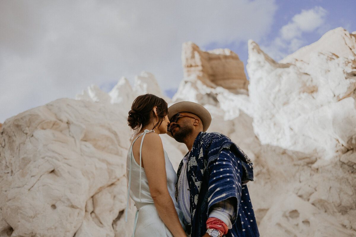 bride and groom together in front of a white rock formation