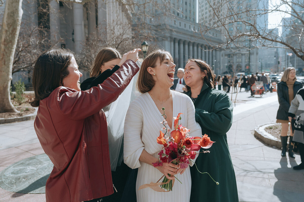 friends fixing brides veil after NY City Hall elopement shot by Elsie Goodman Photography | NYC Elopement Packages