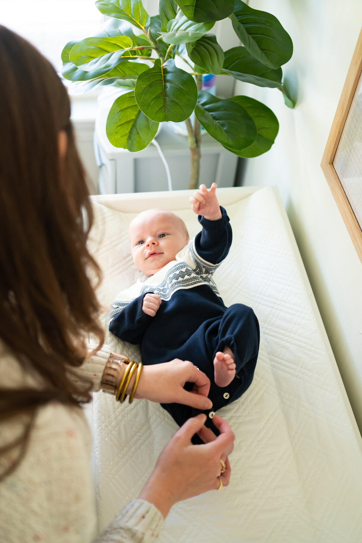 Mom putting new outfit on baby boy