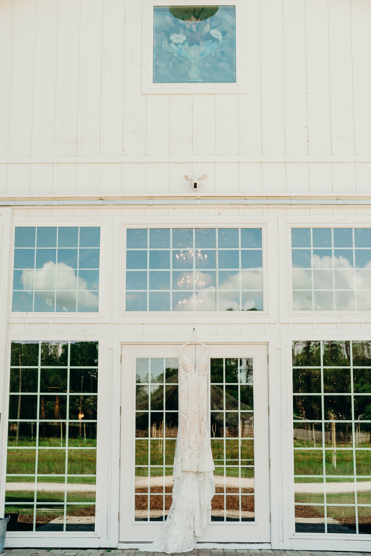 bride dress hanging from venue doors at ever after flower barn