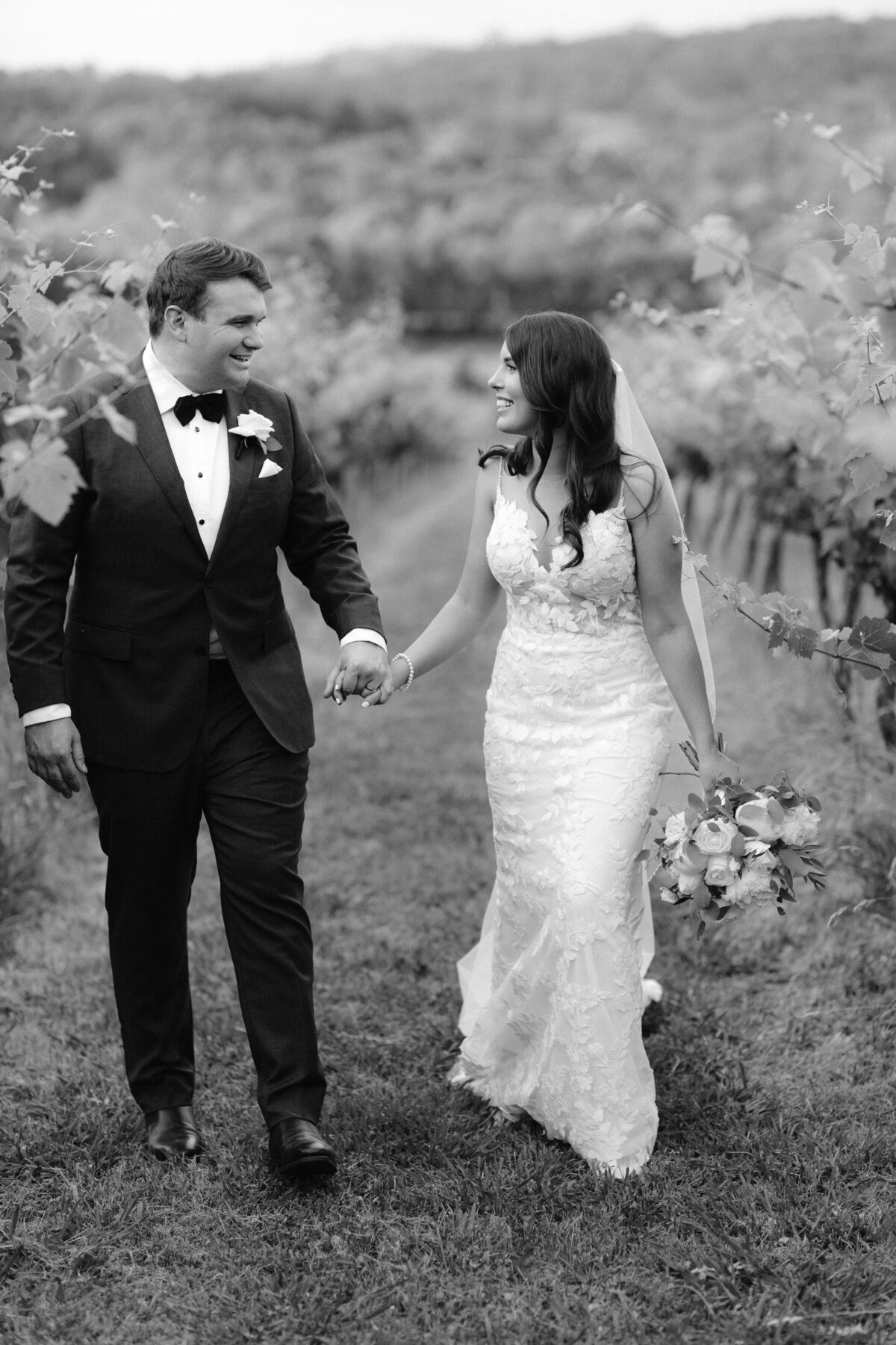 bride and groom walking among the vines