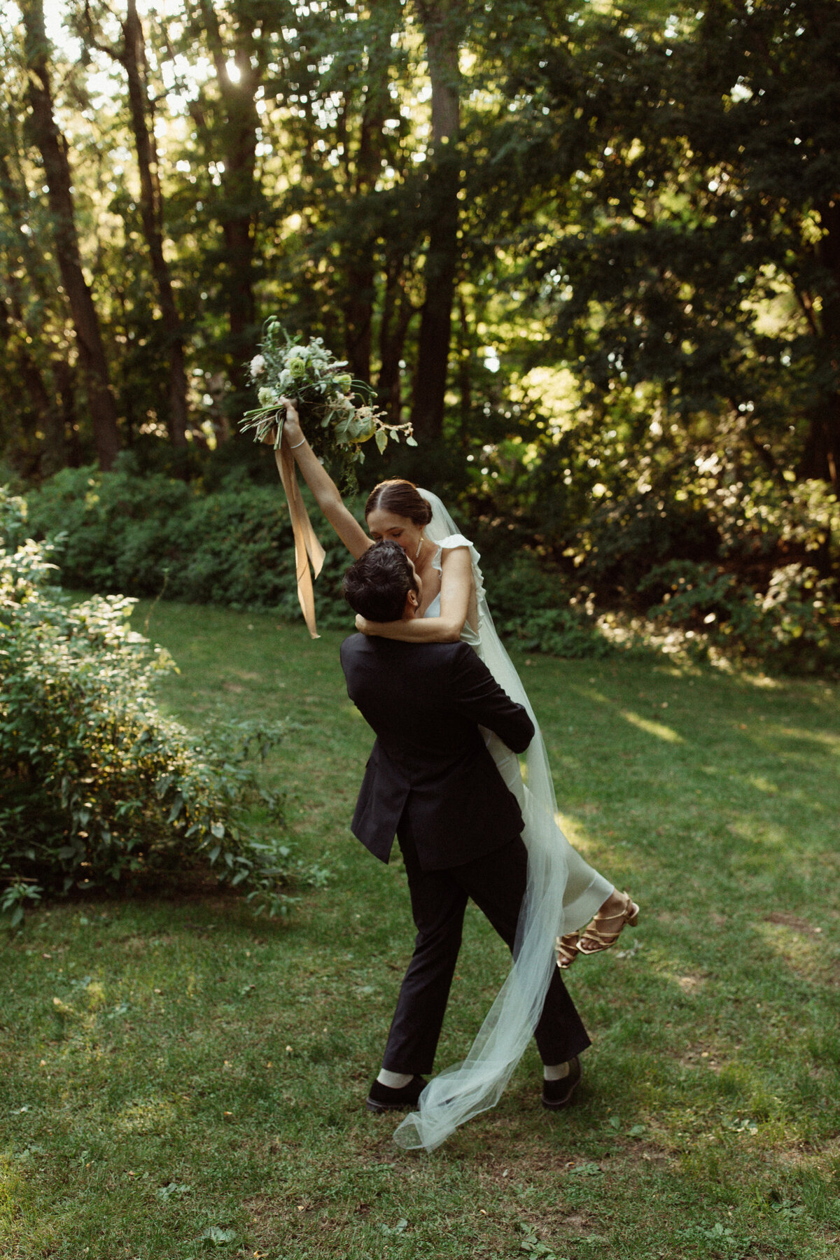 groom picks up bride and spins her around at Kester Homestead wedding in Memphis, NY