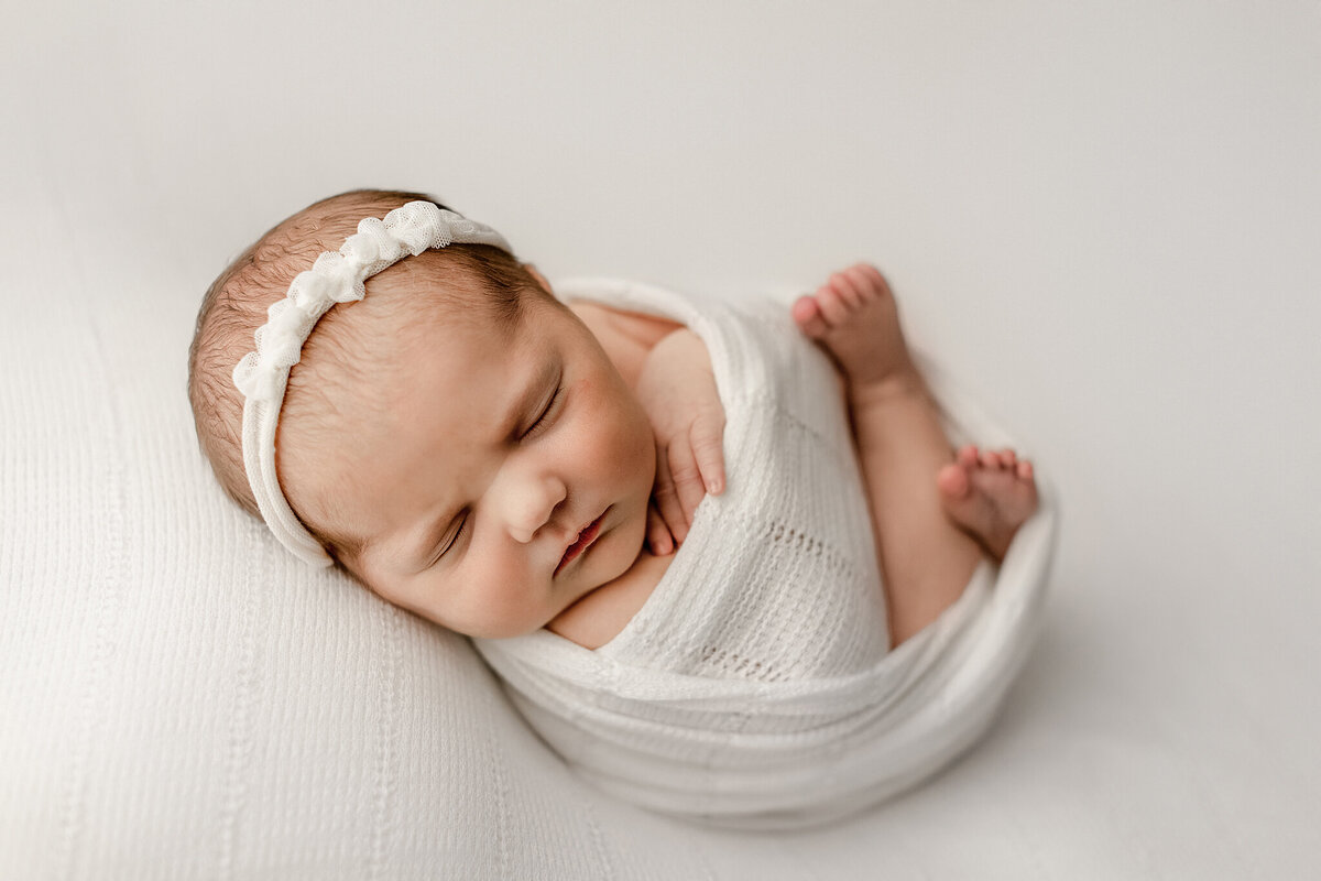 simple newborn posing on cream backdrop in denver newborn  photography studio